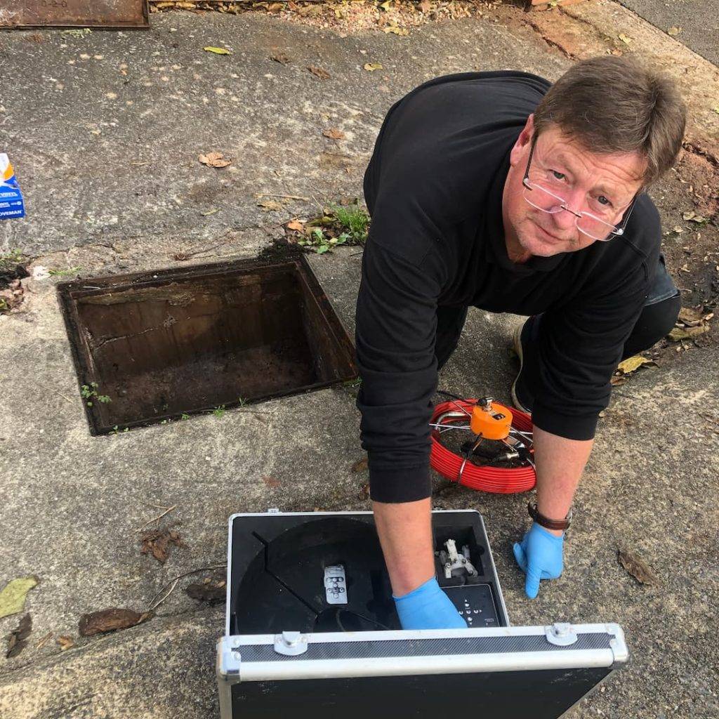 Engineer inspecting a blocked drain